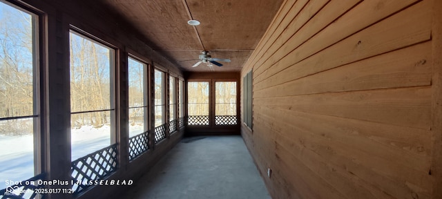 unfurnished sunroom featuring ceiling fan and wood ceiling