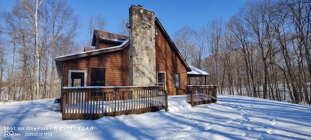 snow covered house with a wooden deck