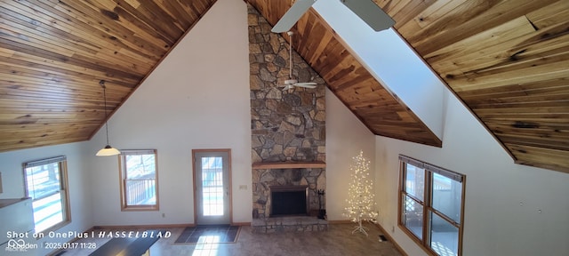 unfurnished living room featuring dark tile patterned floors, high vaulted ceiling, wooden ceiling, and a fireplace