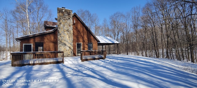 snow covered house with a wooden deck