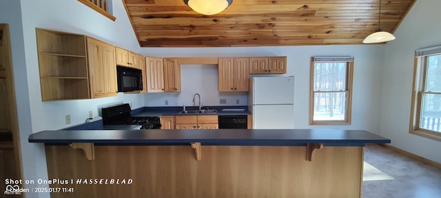 kitchen featuring vaulted ceiling, black appliances, sink, a kitchen breakfast bar, and kitchen peninsula