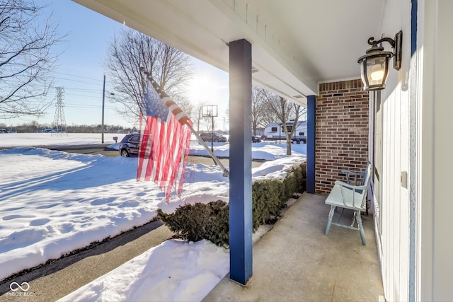 snow covered patio featuring covered porch