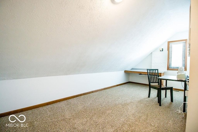 office with a textured ceiling, vaulted ceiling, and carpet