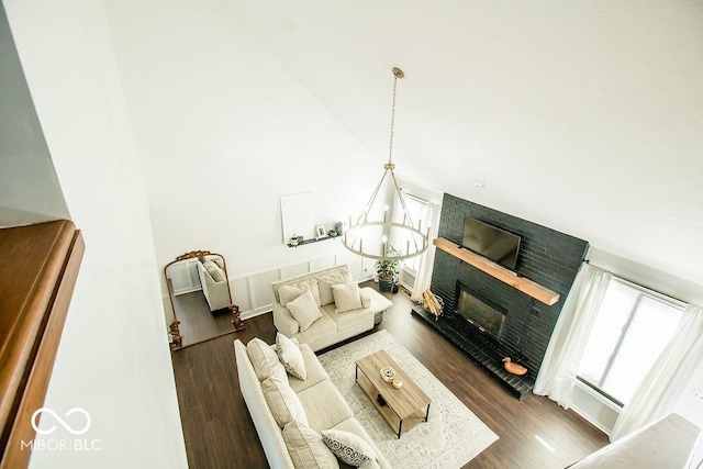 living room featuring a notable chandelier, dark hardwood / wood-style floors, and a fireplace