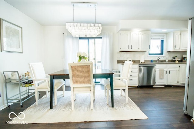 dining area featuring an inviting chandelier, dark hardwood / wood-style flooring, and sink