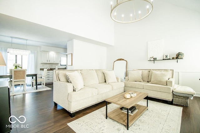 living room with a notable chandelier and dark hardwood / wood-style floors