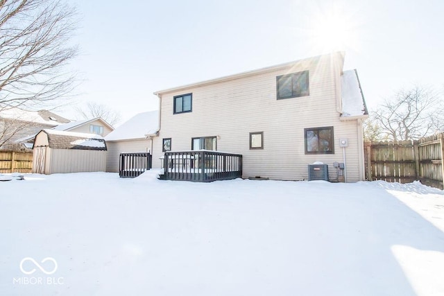 snow covered property with central AC and a deck