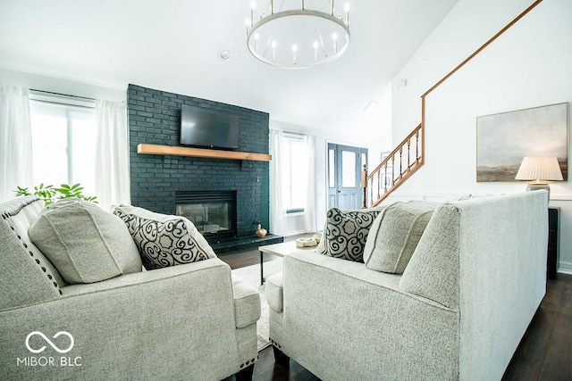 living room featuring a notable chandelier, dark wood-type flooring, and a fireplace