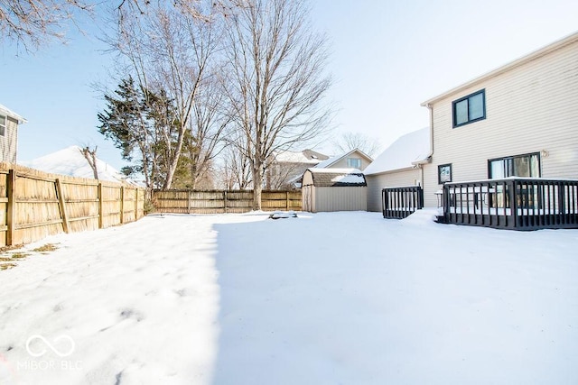 yard covered in snow with a wooden deck