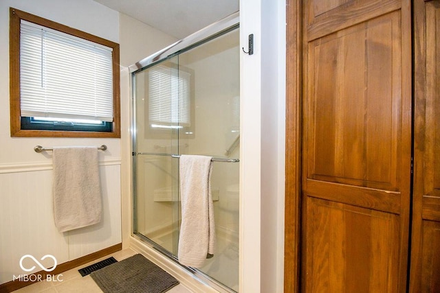 bathroom with tile patterned floors and a shower with shower door