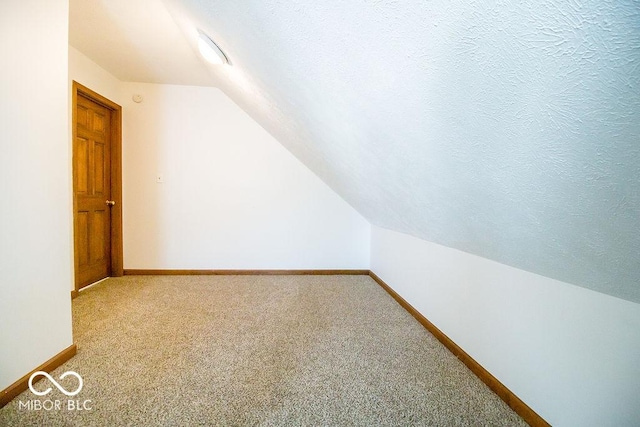 bonus room featuring a textured ceiling, lofted ceiling, and carpet flooring