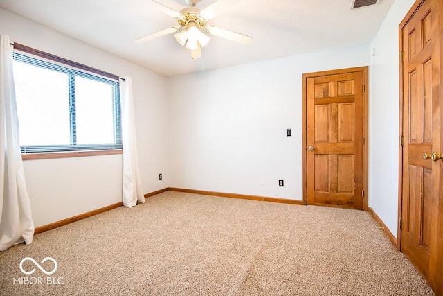 carpeted spare room with ceiling fan