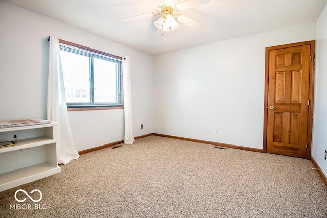 empty room featuring ceiling fan and light colored carpet