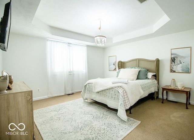 bedroom with light carpet, a raised ceiling, and a chandelier