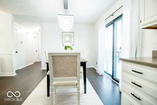 dining area featuring dark wood-type flooring and a notable chandelier