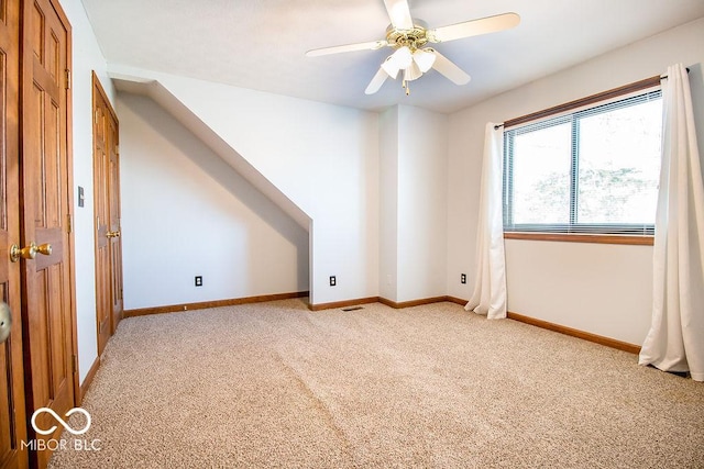 bonus room featuring ceiling fan and light carpet