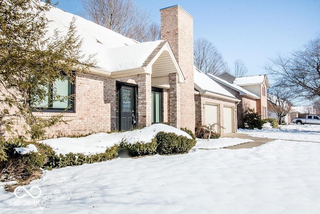 view of snowy exterior featuring a garage