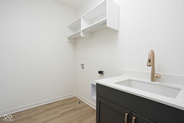 washroom featuring hookup for a washing machine, cabinets, light hardwood / wood-style floors, and sink