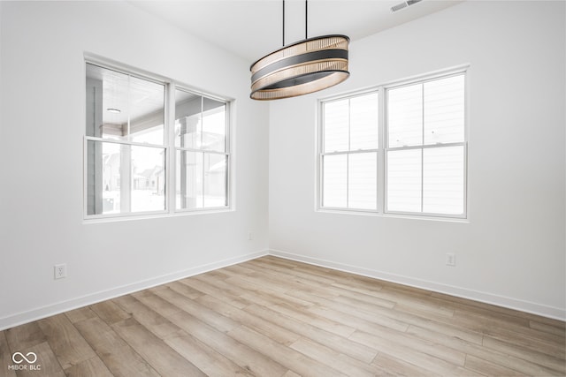 unfurnished dining area with light hardwood / wood-style floors and an inviting chandelier