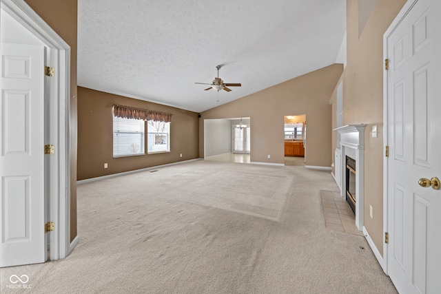 unfurnished living room featuring ceiling fan, light colored carpet, lofted ceiling, and a textured ceiling