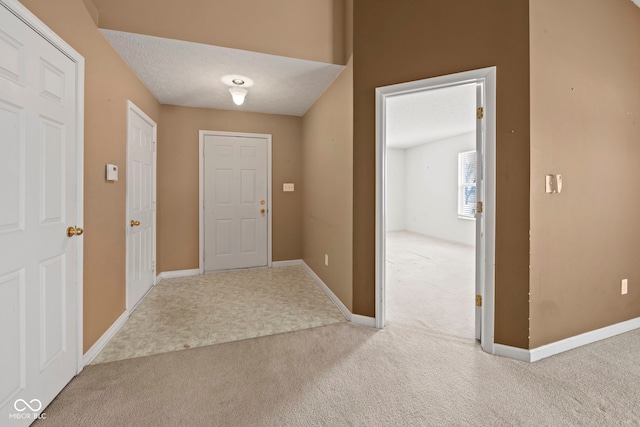 carpeted entrance foyer featuring a textured ceiling