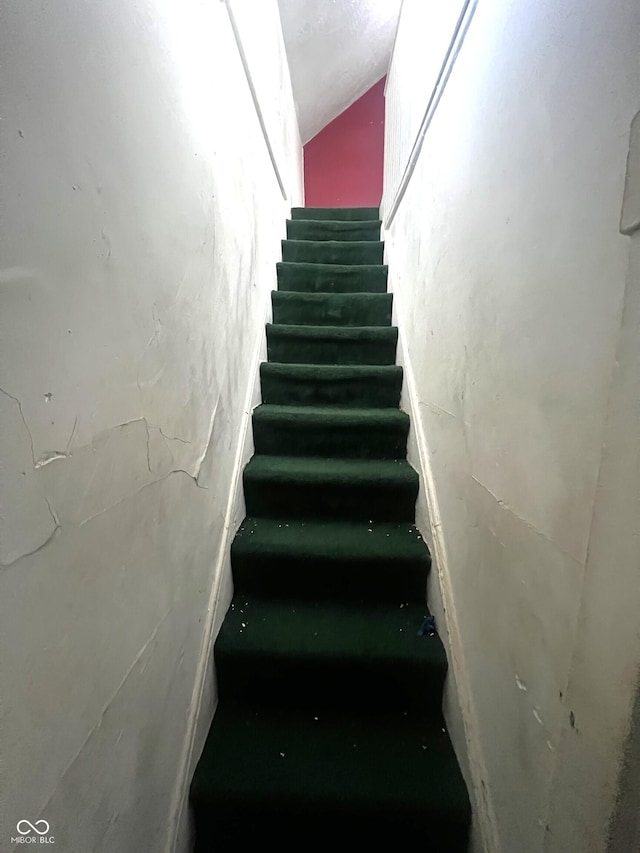 stairway featuring lofted ceiling