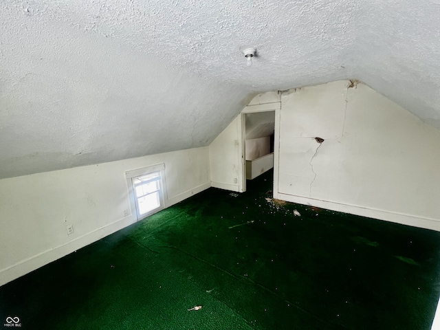 bonus room featuring lofted ceiling and a textured ceiling