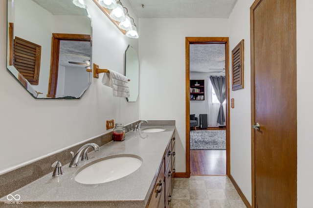 bathroom featuring ceiling fan, a textured ceiling, and vanity