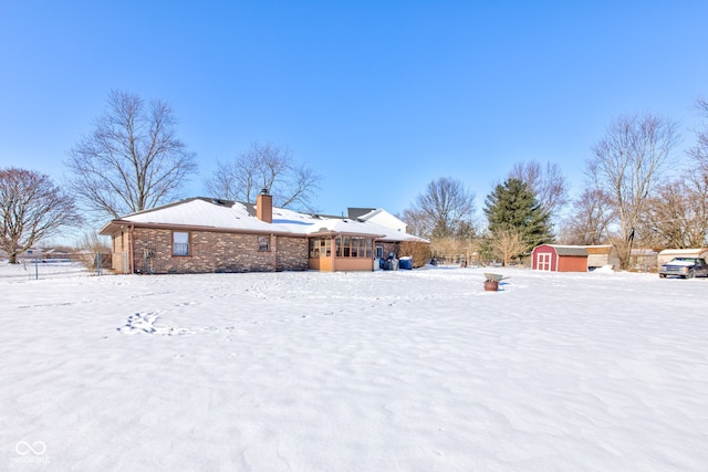 snowy yard featuring a storage unit