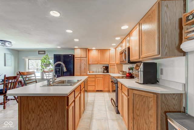 kitchen featuring sink, stainless steel appliances, a breakfast bar, and a kitchen island with sink