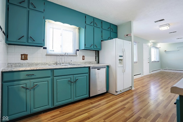 kitchen with sink, stainless steel dishwasher, a baseboard radiator, white fridge with ice dispenser, and decorative backsplash