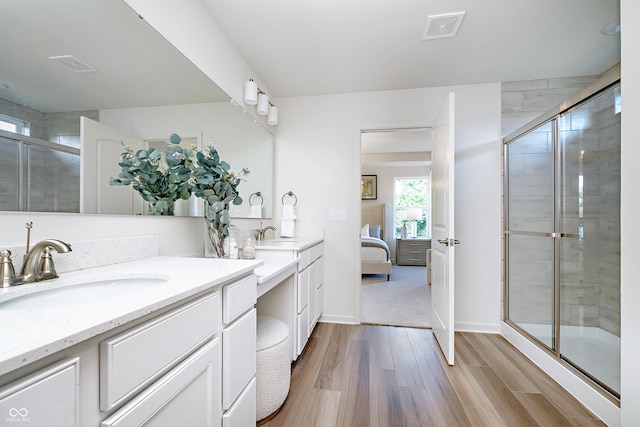 bathroom with walk in shower, vanity, and hardwood / wood-style flooring