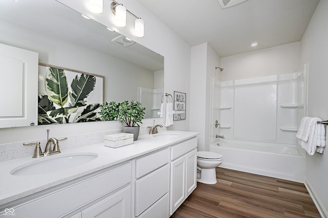 full bathroom with toilet, hardwood / wood-style flooring, shower / washtub combination, and vanity