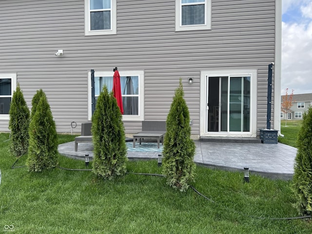 rear view of house featuring a yard and a patio area