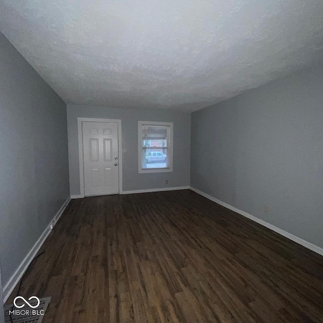 interior space featuring a textured ceiling and dark hardwood / wood-style floors