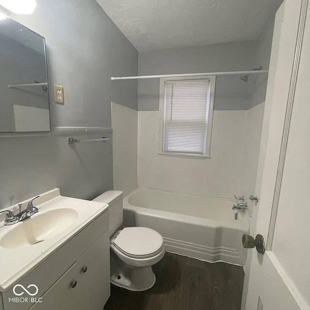 full bathroom with a textured ceiling, hardwood / wood-style floors, shower / tub combination, toilet, and vanity