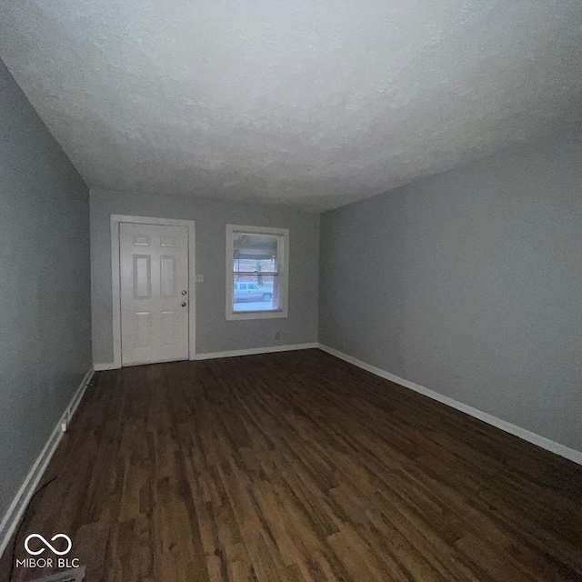 interior space with a textured ceiling and dark wood-type flooring