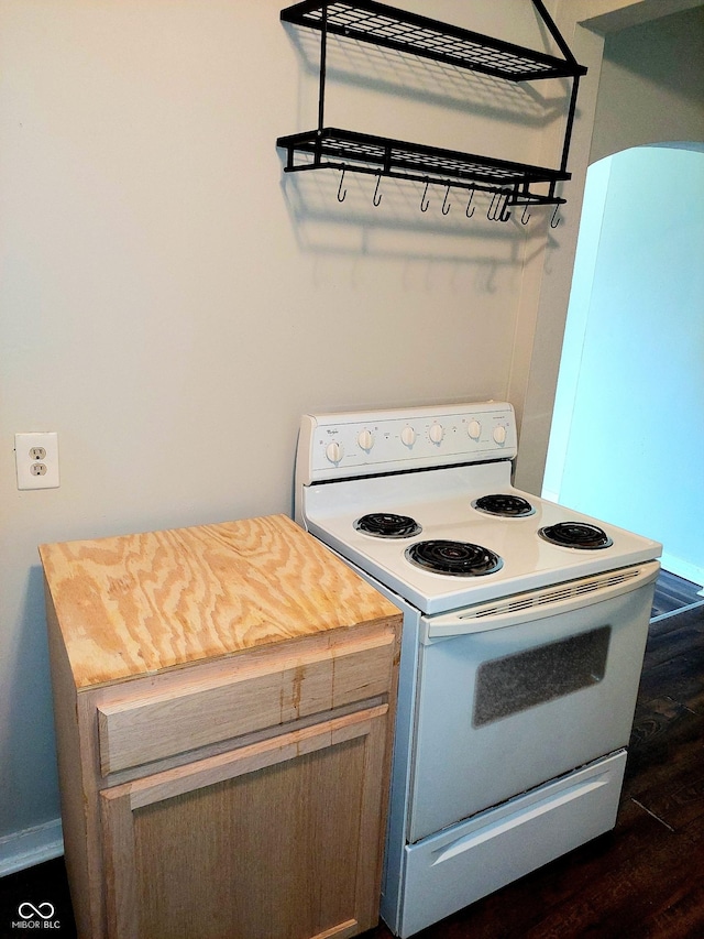 kitchen with butcher block counters, dark hardwood / wood-style floors, and white electric range oven