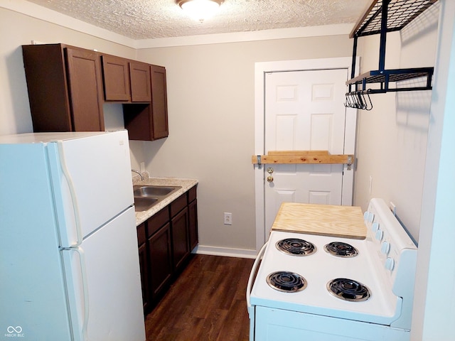 kitchen featuring sink, white appliances, a textured ceiling, and dark wood-type flooring