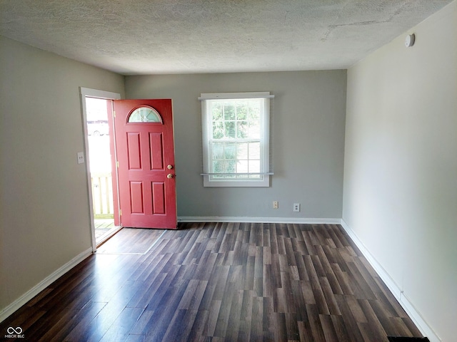 entrance foyer with a textured ceiling and dark wood-type flooring