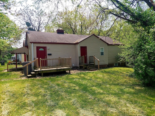 rear view of property featuring a lawn and a wooden deck