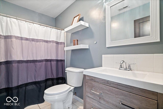 bathroom featuring tile patterned floors, toilet, vanity, and a textured ceiling