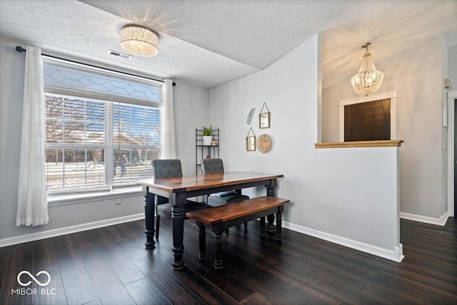 dining space featuring dark hardwood / wood-style floors, a chandelier, and a textured ceiling