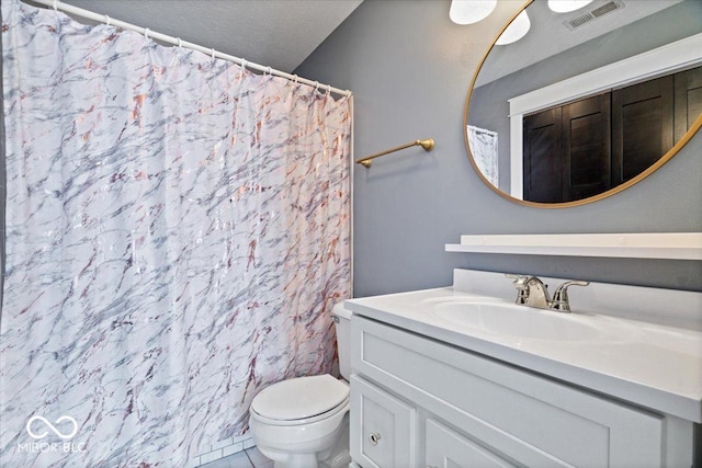 bathroom featuring toilet, vanity, tile patterned floors, and a textured ceiling