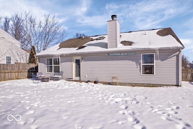 snow covered rear of property featuring an outdoor fire pit