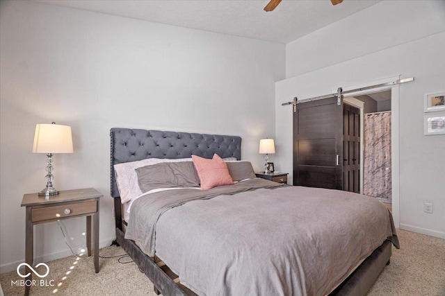 carpeted bedroom featuring ceiling fan and a barn door