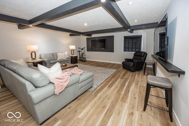 living room featuring a textured ceiling, light hardwood / wood-style floors, and beam ceiling