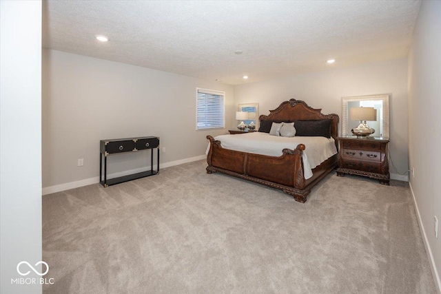 bedroom featuring light colored carpet and a textured ceiling