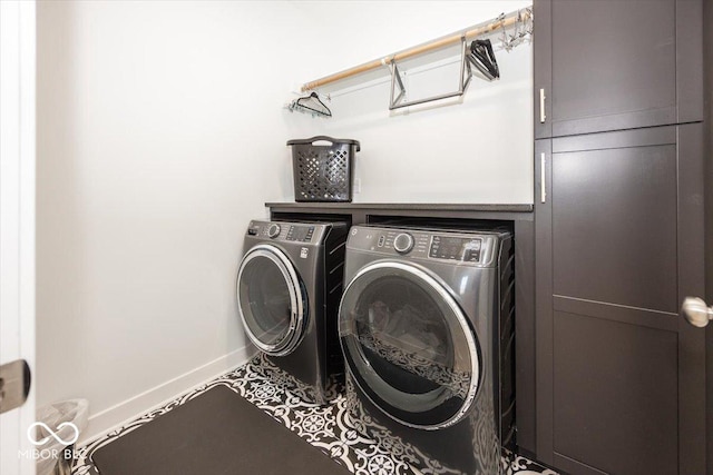 washroom with cabinets and washer and clothes dryer