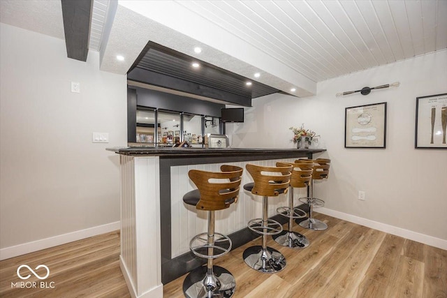 bar with wooden ceiling and light hardwood / wood-style flooring